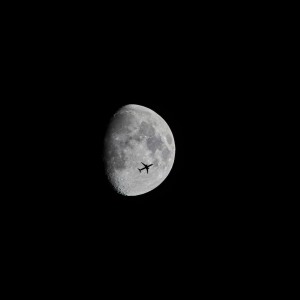 Foto de un avión pasando por delante de la luna
